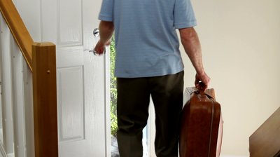 Man Walking Out Door With Suitcase